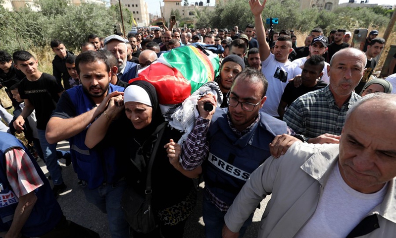 People carry the body of killed journalist Shireen Abu Akleh during her funeral in the West Bank city of Jenin, on May 11, 2022.(Photo: Xinhua)