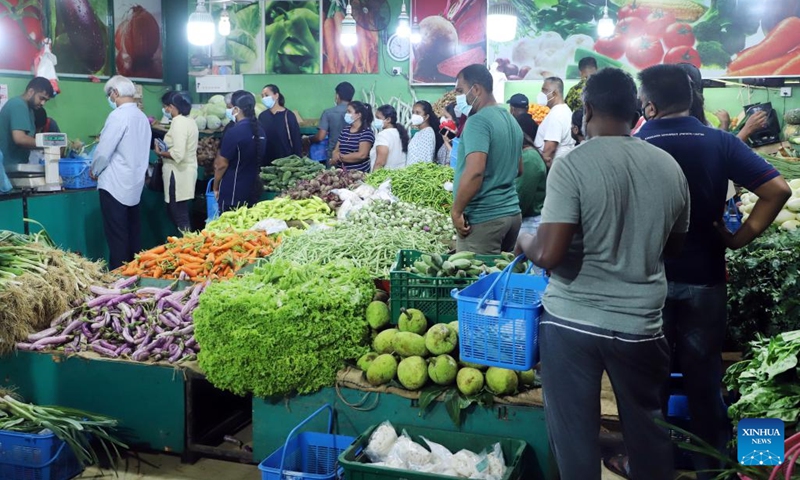 People buy vegetables from a market after the authorities relaxed the curfew for a few hours in Colombo, Sri Lanka, May 12, 2022. Sri Lanka imposed a nationwide curfew following violent clashes in the capital Colombo on May 9.(Photo: Xinhua)