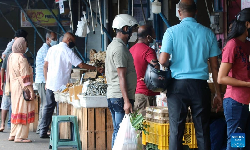 People buy vegetables from a market after the authorities relaxed the curfew for a few hours in Colombo, Sri Lanka, May 12, 2022. Sri Lanka imposed a nationwide curfew following violent clashes in the capital Colombo on May 9.(Photo: Xinhua)