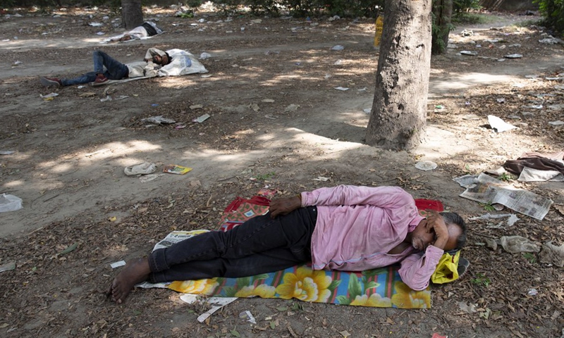 People take naps under shades of trees to get respite from the hot summer day in New Delhi, May 12, 2022.(Photo: Xinhua)