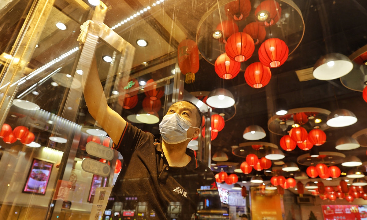 A restaurant staff member cleans a window on June 5, 2022 to prepare for the first batch of customers at the restaurant after a hiatus of more than a month.  Beijing will resume catering services for restaurants from June 6 after a resurgence of COVID-19 was largely stemmed.  Photo: Li Hao/GT 