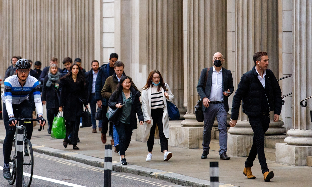 Morning commuters pass the Bank of England in the City of London on January 27, 2022 Photo: VCG