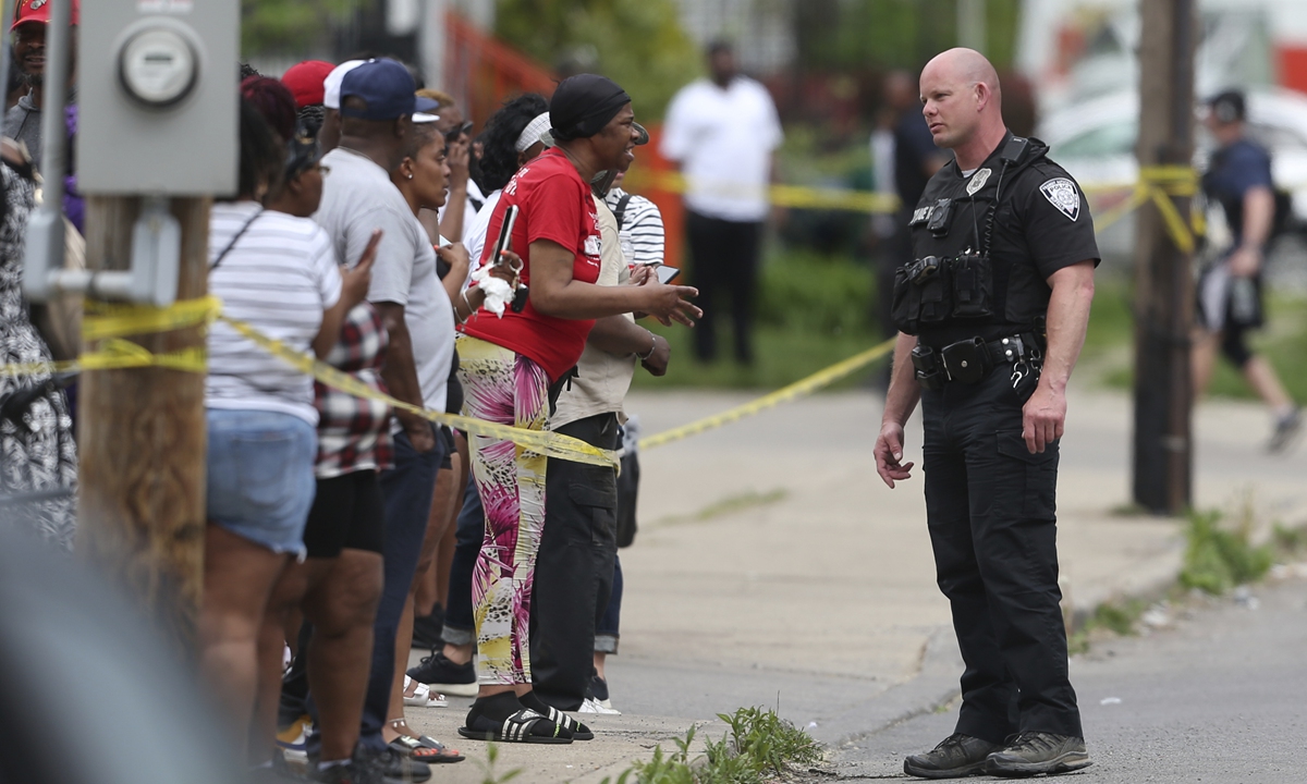 Police speak to bystanders while investigating at a scene where an 18-year-old white man shot dead 10 people in a black neighborhood in what authorities are calling a racially motivated attack in the city of Buffalo on May 14, 2022. Photo: VCG