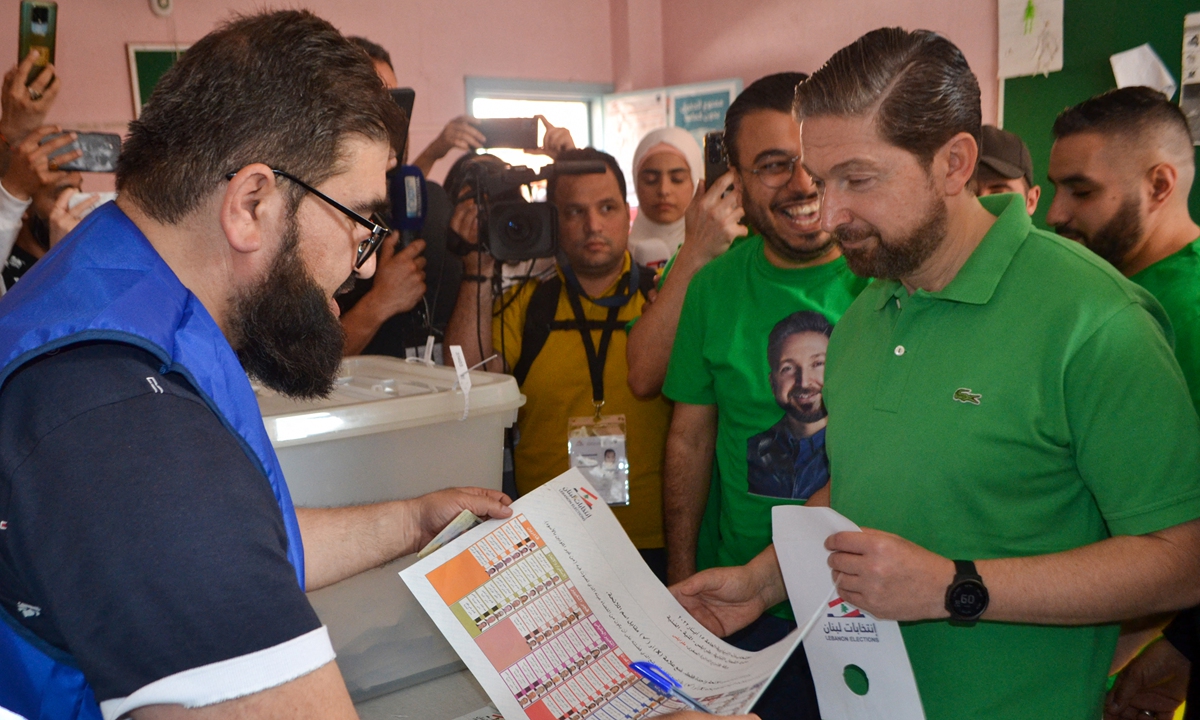 Lebanese MP Faisal Karameh (right) casts his ballot in the parliamentary election at a polling station in the northern Lebanese city of Tripoli, on May 15, 2022. The parliamentary election is a first test for opposition movements spawned by an unprecedented anti-establishment uprising in 2019 that briefly raised hopes of government change in Lebanon. Photo: AFP
