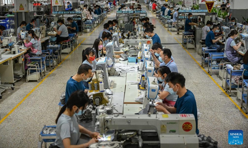 Staff members work on a production line in the manufacturer of 361 Degrees in Jinjiang City, southeast China's Fujian Province, May 13, 2022.Photo:Xinhua