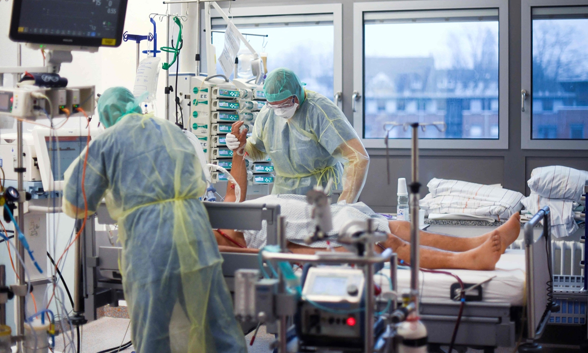 Medical staff assist a patient infected with COVID-19 in the intensive care unit of a hospital in Bochum, Germany, on December 16, 2021. Photo: VCG