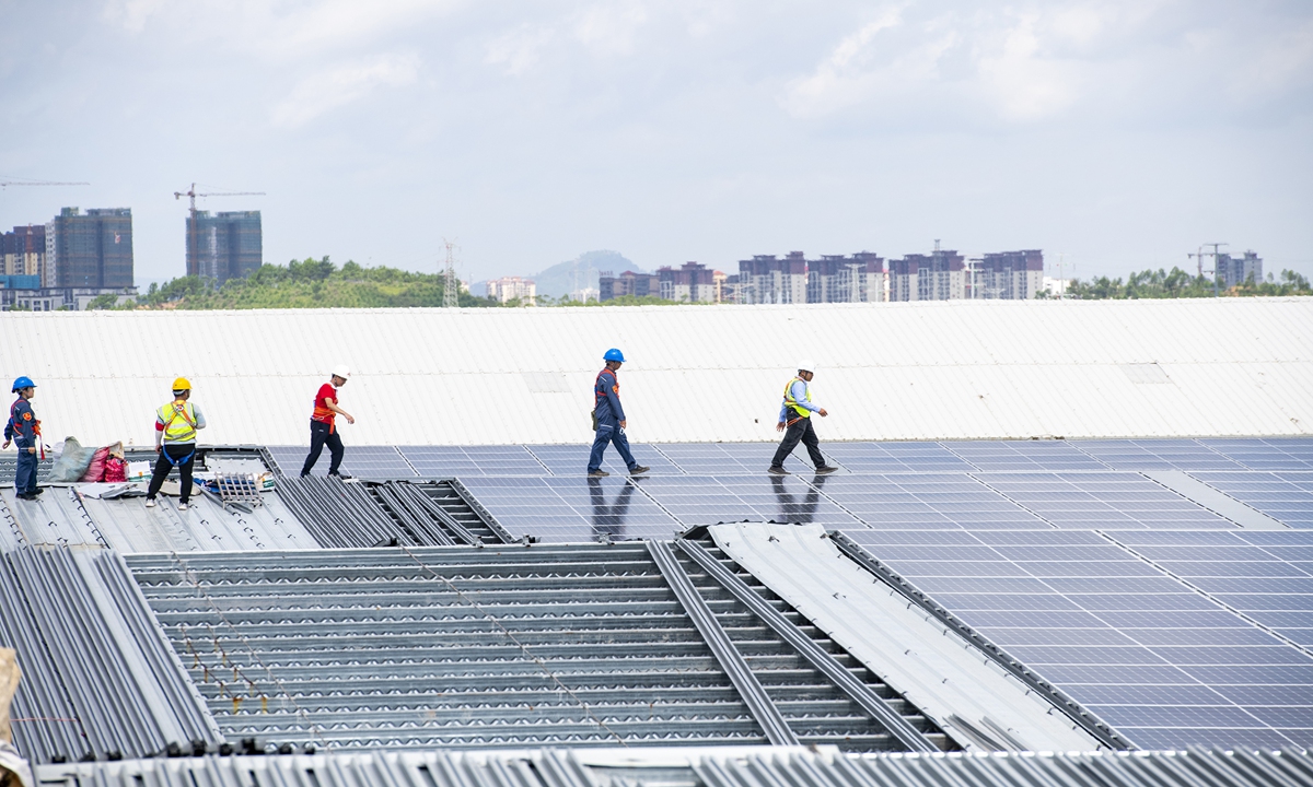 Workers install solar power generation modules on a factory's roof in Teng County, South China's Guangxi Zhuang Autonomous Region, on June 23, 2022. The project is expected to avoid the use of 7,014 tons of standard coal annually, cutting carbon dioxide by 1,754 tons. Provinces across China are encouraging rooftop solar projects to help achieve the country's dual carbon goals. Photo: VCG
