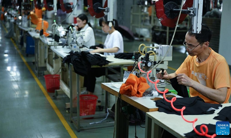 Staff members work on a production line in the manufacturer of 361 Degrees in Jinjiang City, southeast China's Fujian Province, May 13, 2022.Photo:Xinhua