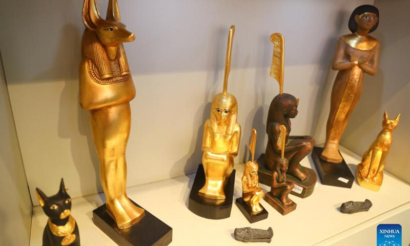 Photo taken on May 14, 2022 shows the replica of the statue of god Anubis at the souvenir store of Egyptian Museum in Cairo, Egypt. As a funerary deity, Anubis is associated with mummification, funerary rituals, and the cemetery in ancient Egyptian myth, usually depicted as a black canine, or a man with canine head. It can be found at large numbers of pharaonic antiquities at the world-known Egyptian Museum. (Xinhua/Sui Xiankai)