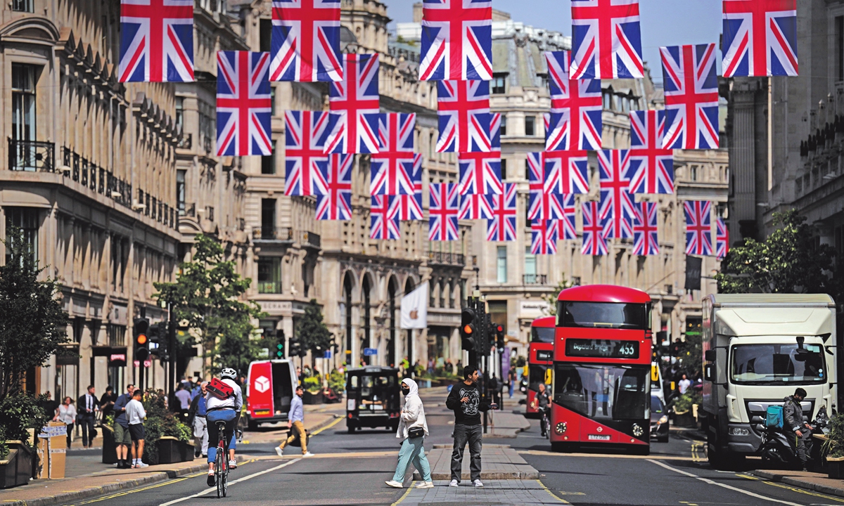 People cross the Regent Street shopping district with Union flags hanging over it to mark the Platinum Jubilee of the 70-year reign of Britain's Queen Elizabeth II, in London, on May 18, 2022. UK's inflation rate rose to the highest level in 40 years last month as the Ukraine crisis fueled further increases in food and fuel prices. Photo: VCG