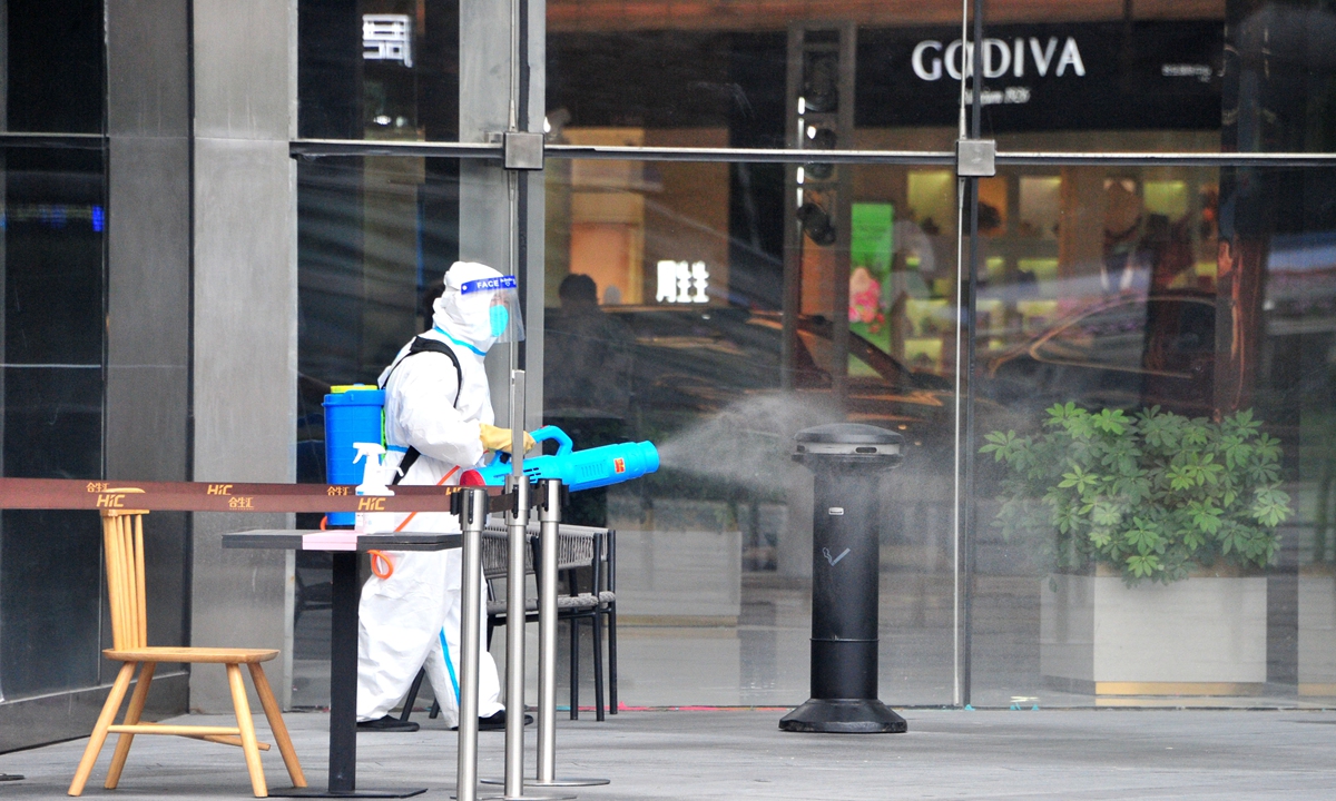 A cleaner wearing protective clothing disinfects the surrounding public area of a shopping mall in Yangpu district, Shanghai, on June 13, 2022. As of 8 am on June 13, Shanghai reported 28 confirmed cases related to a Suning retail store near Wujiaochang, a roundabout-centered area in Yangpu, with 126,000 related people testing negative for COVID-19. Photo: VCG