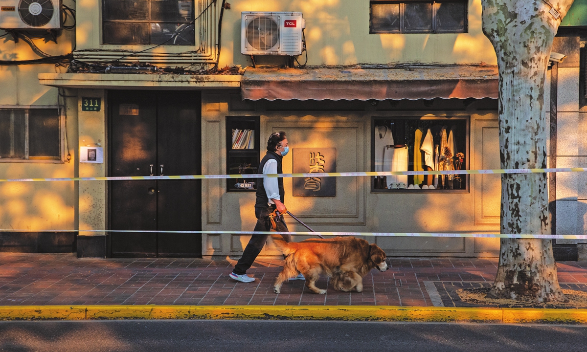 A Shanghai resident walks his golden retriever on May 16, 2022 when the city gradually resumes small businesses. Photo: Wu Chuanhua/Global Times 