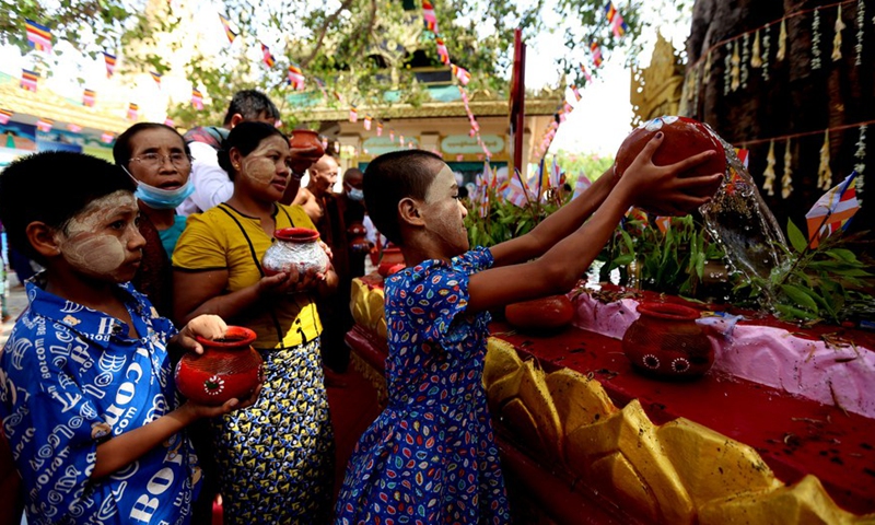 A girl waters a Bodhi Tree at the Shwedagon Pagoda in Yangon, Myanmar, May 14, 2022.Photo:Xinhua