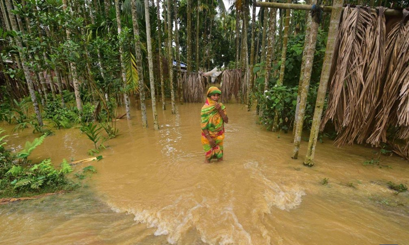 A woman wades through a flooded area of Bakula Guri village in Nagaon district of India's northeastern state of Assam, May 15, 2022.Photo:Xinhua