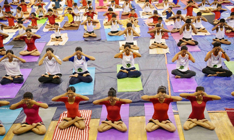 The National Service Scheme (NSS) volunteers perform yoga in the indoor hall of the state sports complex at Agartala, the capital city of India's northeastern state of Tripura, May 14, 2022.Photo:Xinhua