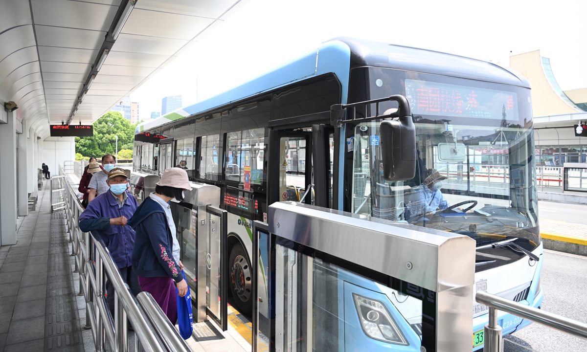 People wait in line to get on a bus. Bus service partly resumed in Shanghai on May 16. Photo: thepaper.cn