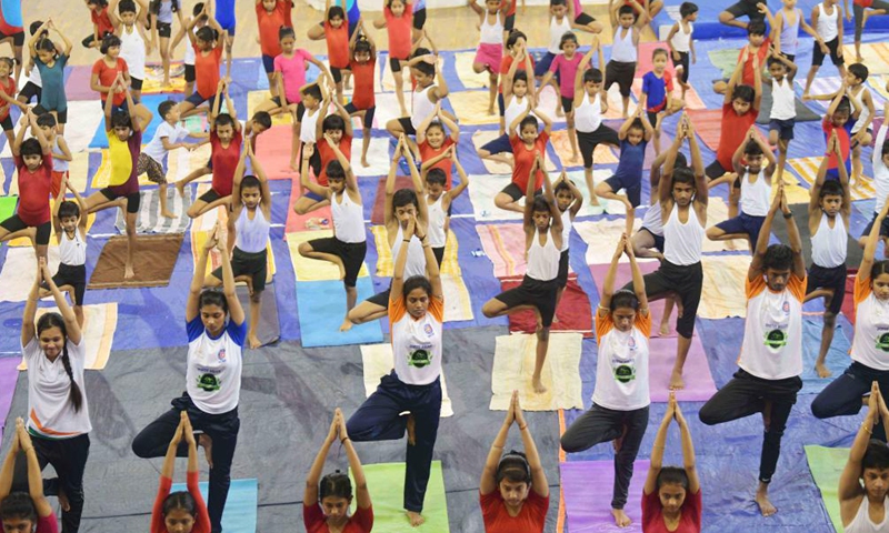 The National Service Scheme (NSS) volunteers perform yoga in the indoor hall of the state sports complex at Agartala, the capital city of India's northeastern state of Tripura, May 14, 2022.Photo:Xinhua