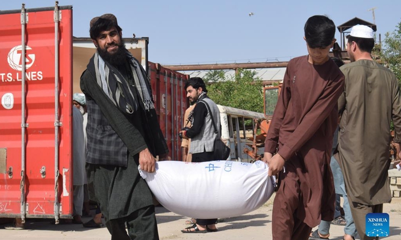 People unload food from a container in Jawzjan, Afghanistan, May 16, 2022. More than 7,000 families have received food assistance in two Afghan provinces in recent days, authorities said on Monday.(Photo: Xinhua)