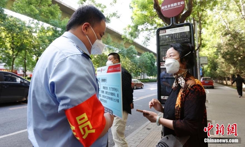 A staff member checks a passenger's health code at a bus station in Beijing, May 17, 2022. (Photo: China News Service/Han Haidan)
