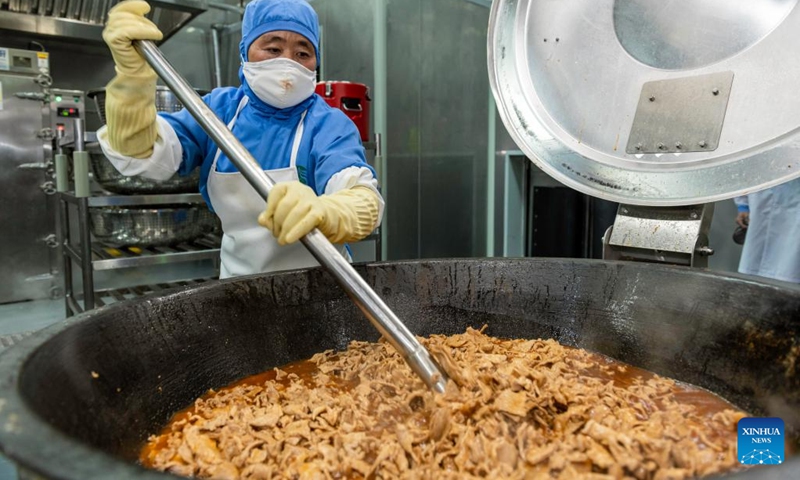 A staff member makes food at a catering company in Lhasa, southwest China's Tibet Autonomous Region, May 12, 2022. With the operation of a catering company, some 12,000 students of six primary schools in Chengguan District of Lhasa now enjoy nutritious lunches.(Photo: Xinhua)