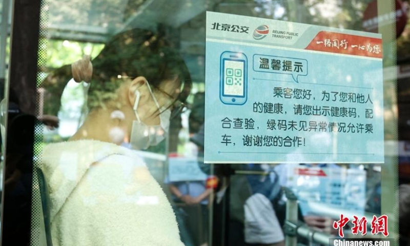 An epidemic prevention announcement is posted on a bus window to remind passengers to show their health codes, Beijing, May 17, 2022. (Photo: China News Service/Han Haidan)