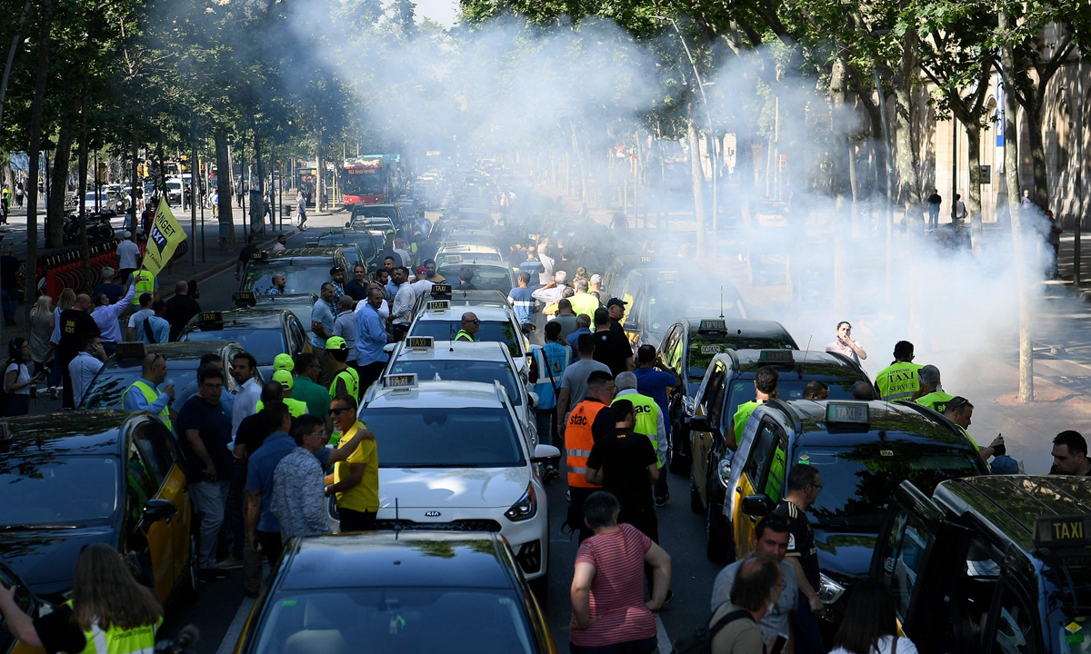 Taxi drivers take part in a demonstration calling for measures to limit the number of Tourism Vehicles with Chauffeur (VTC) to a ratio of one VTC for 30 taxis, in Barcelona, Spain, on May 18, 2022.  Photo: VCG