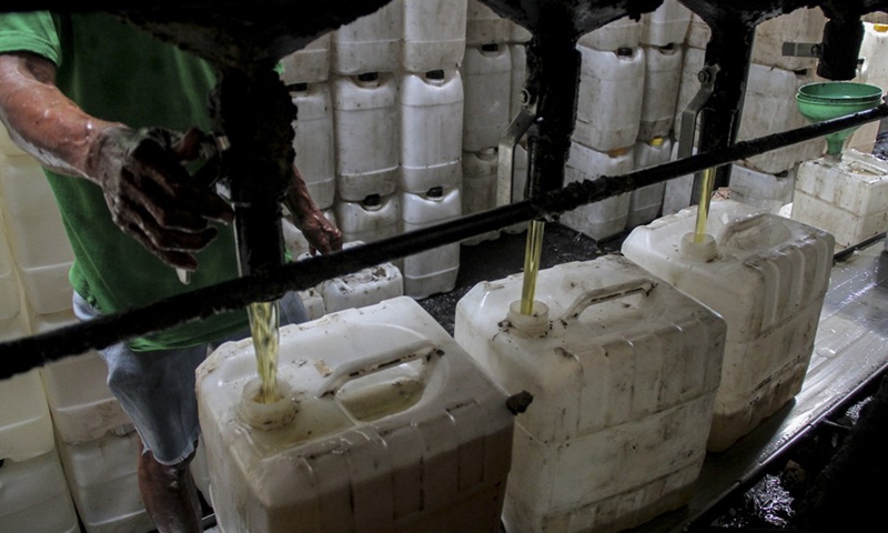A worker processes cooking oil for distribution at a traditional market in Bogor, West Java, Indonesia, May 17, 2022.(Photo: Xinhua)