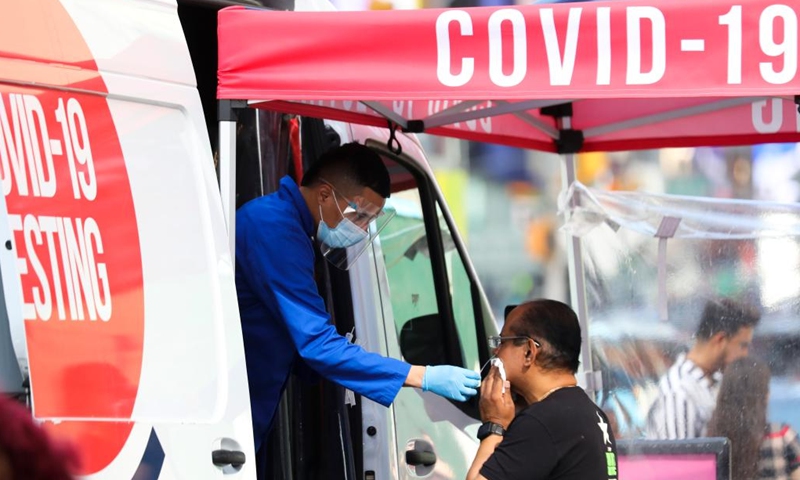 A medical worker collects a swab sample from a man at a COVID-19 testing site on Times Square in New York, the United States, May 17, 2022.(Photo: Xinhua)
