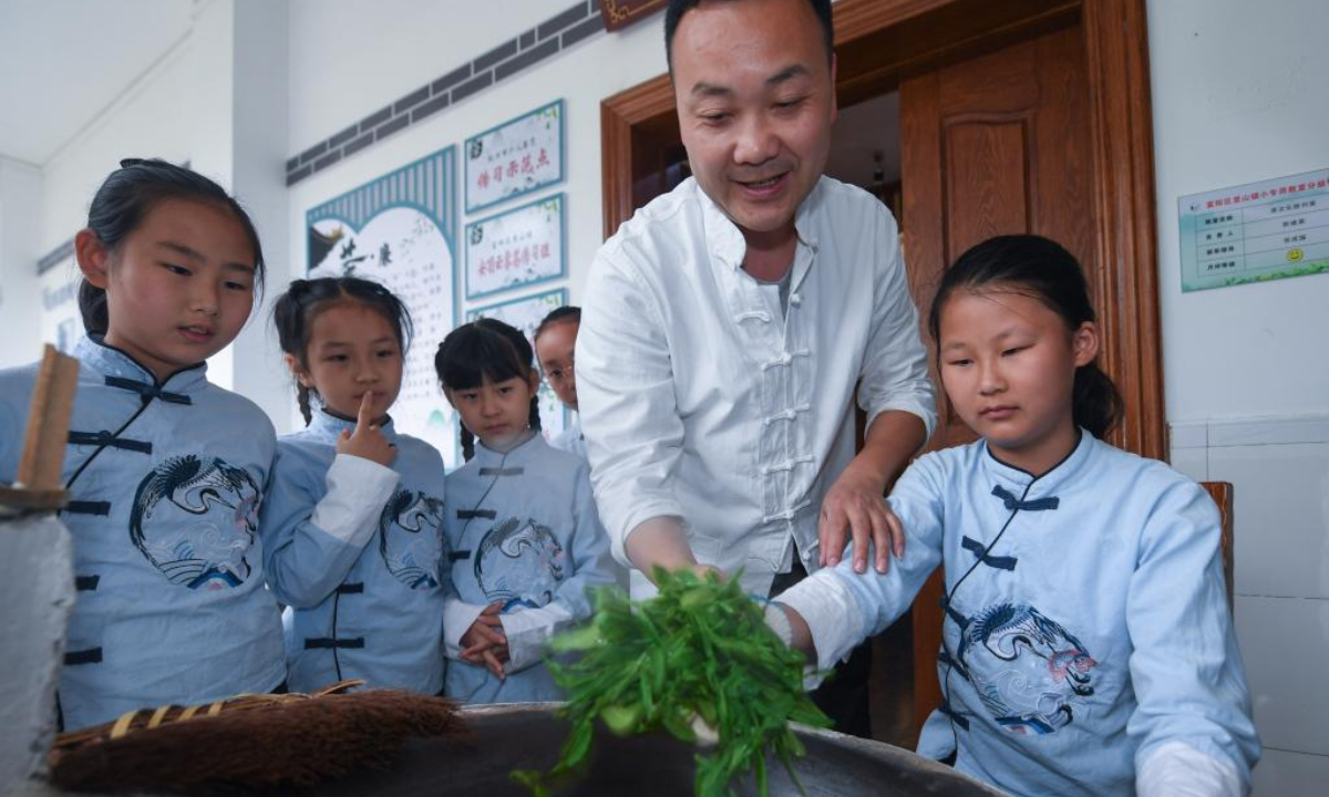 Students experience tea making at a primary school in Lishan Town in Fuyang District of Hangzhou, east China's Zhejiang Province, May 20, 2022. Lishan Town held a series of activities to promote the traditional Chinese tea culture and greet the International Tea Day, which falls on May 21 annually. Photo:Xinhua