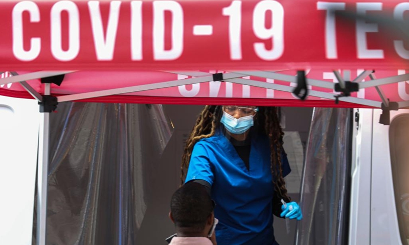 A medical worker collects a swab sample from a man at a COVID-19 testing site on Times Square in New York, the United States, May 17, 2022.(Photo: Xinhua)
