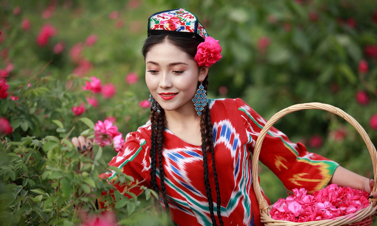 A Uygur girl from Hotan Prefecture picks flowers. Photo: Adili Nadir