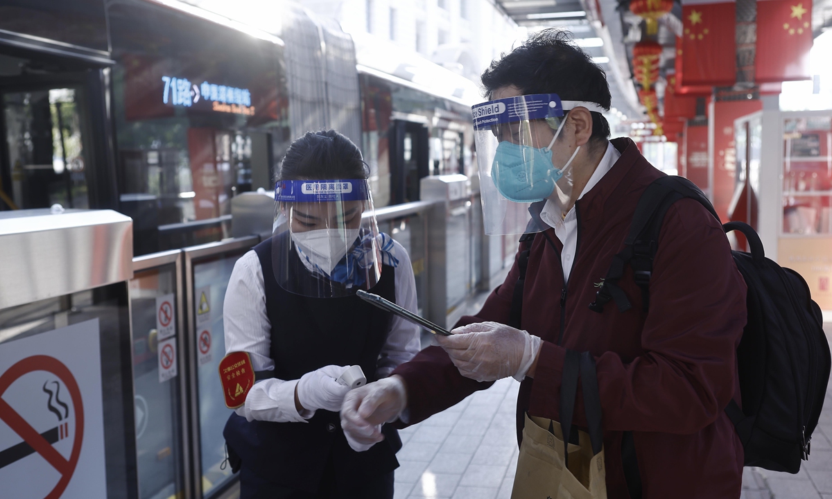 A passenger gets a temperature check before boarding a bus in Shanghai on Sunday, May 22, 2022. The East China city is resuming the operation of four of its metro lines and 273 bus routes that form a core transportation network after strict anti-virus restrictions. Photo: VCG