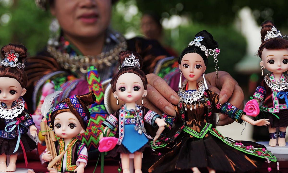 A Miao woman displays her handmade Barbie dolls wearing traditional Miao ethnic costumes at a launch ceremony for a tourism and art week in Rongshui Miao Autonomous County in Liuzhou, South China's Guangxi Zhuang Autonomous Region on May 19, 2022. 
Photo:cnsphoto