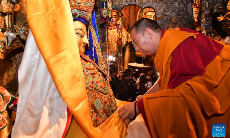 Panchen Erdeni Chos-kyi rGyal-po presents hadas -- silk scarves used to express respect and greeting -- to Buddhist statues, in the Jokhang Temple in Lhasa, capital city of southwest China's Tibet Autonomous Region, on May 18, 2022.(Photo: Xinhua)