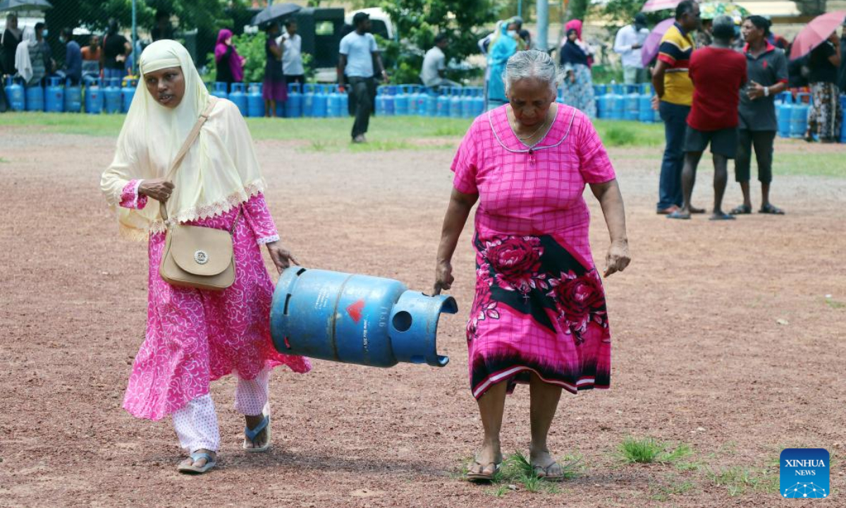 People carry a gas cylinder in Maradana, the suburb of Colombo, Sri Lanka, on May 20, 2022. Due to fuel shortages, there have been long queues in front of various gas stations on the streets of Colombo this week. Photo:Xinhua
