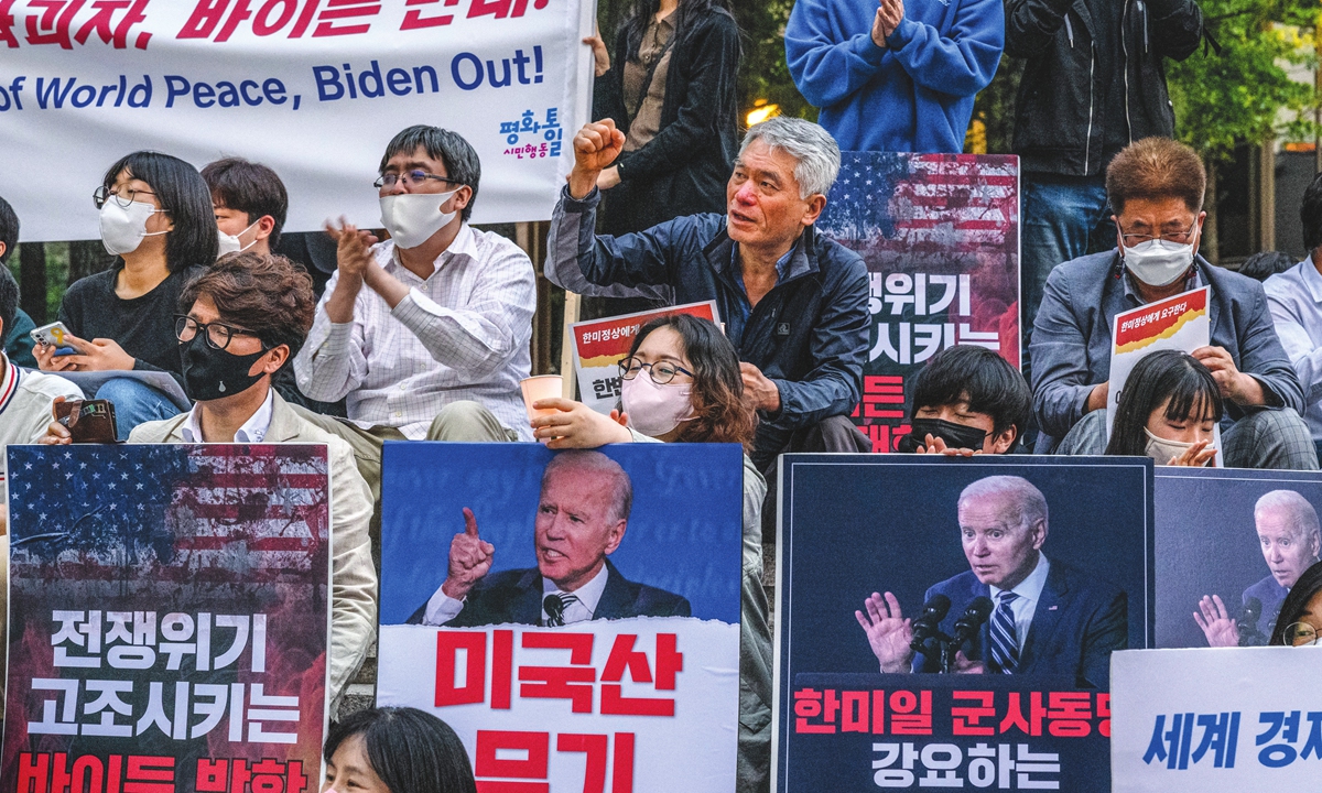 Activists hold candles and placards as they protest against US President Joe Biden's visit to South Korea in Seoul on May 20, 2022. After a three-day visit to South Korea beginning on that day, Biden will travel to Tokyo. Photo: AFP