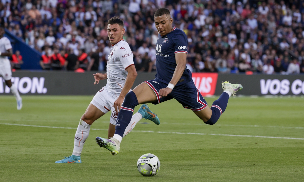 Kylian Mbappe (right) of Paris Saint-Germain holds off William Mikelbrencis of FC Metz on May 21, 2022 in Paris, France. Photo: VCG