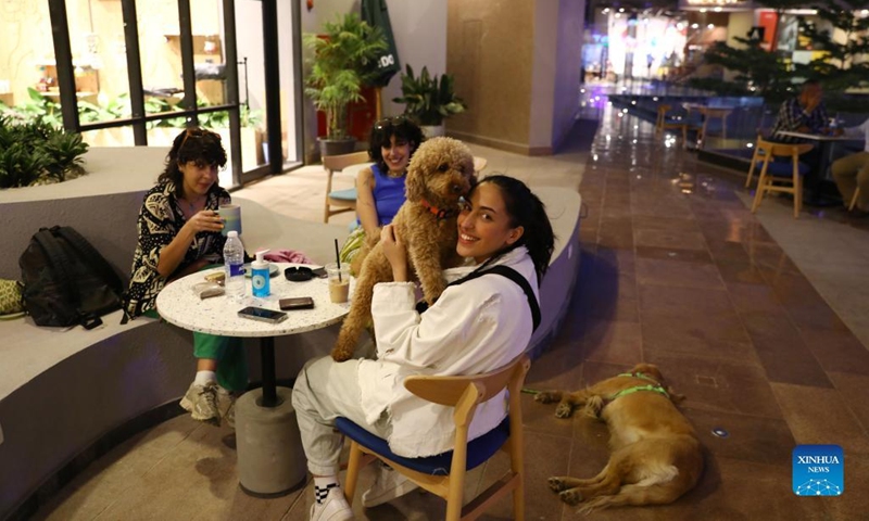 People spend time with their dogs at a dog cafe in Giza, Egypt, on May 15, 2022.Photo:Xinhua