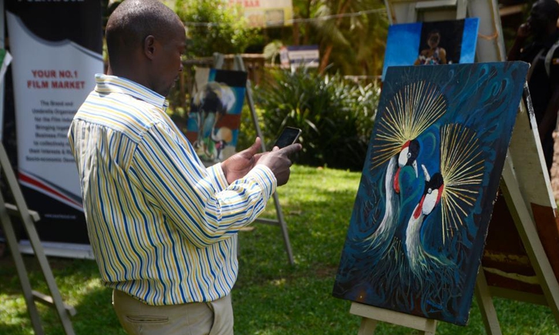 A visitor takes photos of a painting during an event to mark World Day for Cultural Diversity for Dialogue and Development at Uganda National Cultural Center in Kampala, Uganda, on May 21, 2022.Photo:Xinhua