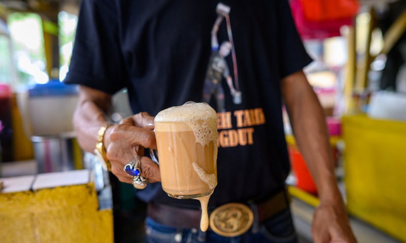 Photo taken on May 18, 2022 shows a man carrying Teh tarik in Selangor's Petaling Jaya, Malaysia.Photo:Xinhua