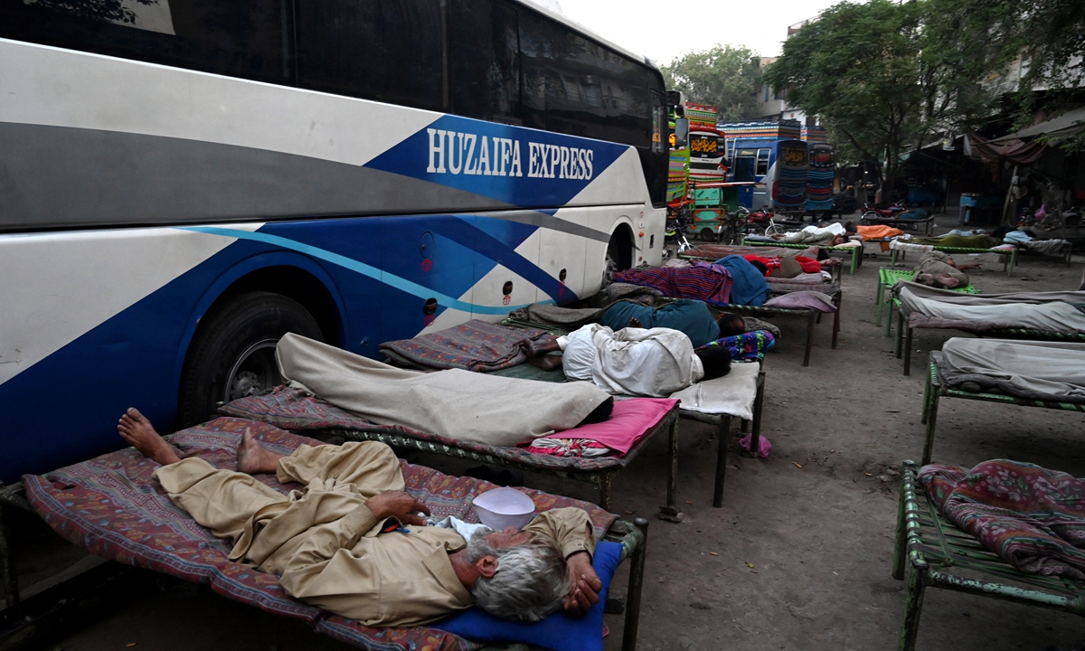 Drivers sleep at a bus station in Lahore,Pakistan on May 22, 2022. Since April, an unpredictable heat wave has hit South Asian nations that have seen temperatures reach up to 50 C. Photo: AFP