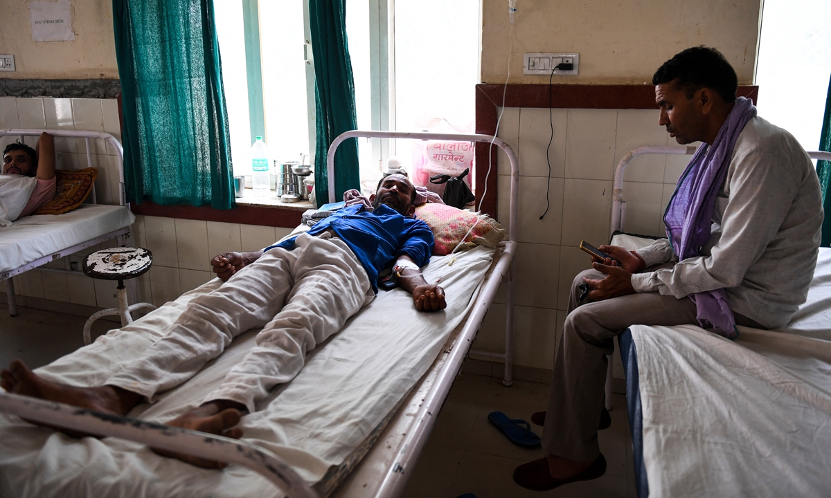 An Indian patient lies on a bed at a government hospital after suffering from heat stroke in Churu, India on June 4, 2019. Photo: AFP