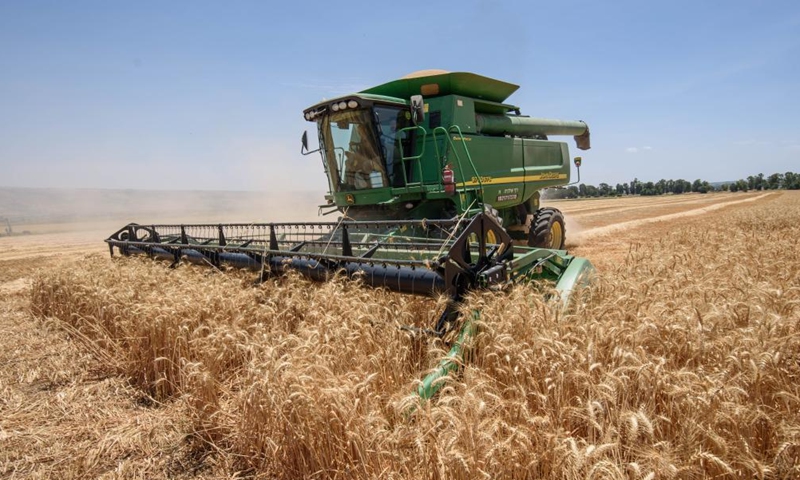A combine harvester harvests a wheat field in the hula valley near northern Israeli city of Kiryat Shemona on May 22, 2022.Photo:Xinhua