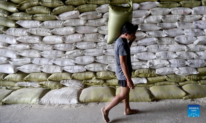 A worker carries a rice bag at a warehouse in Yangon, Myanmar, May 22, 2022.Photo:Xinhua