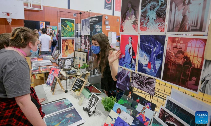 A comic artist speaks with visitors at her booth during the Vancouver Comic Art Festival in Vancouver, British Columbia, Canada, on May 22, 2022.Photo:Xinhua