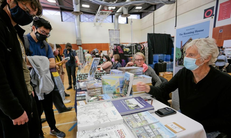 A comic artist talks with visitors at a booth during the Vancouver Comic Art Festival in Vancouver, British Columbia, Canada, on May 22, 2022.Photo:Xinhua