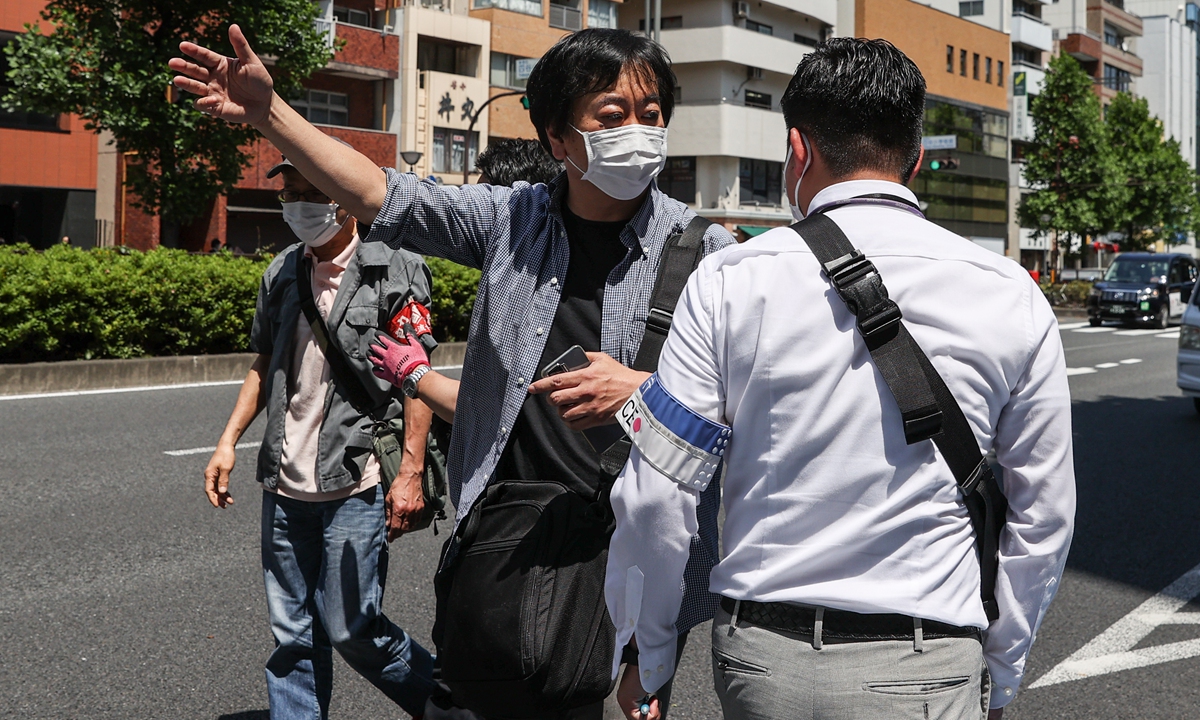 A man argues with police officers during the march to protest against Quad Summit in Tokyo, Japan on May 24, 2022. US President Joe Biden arrived in Japan after his visit to South Korea, part of a tour of Asia aimed at reassuring allies in the region. Biden also takes part in the Quad Leaders' summit during his visit. Photo: VCG
