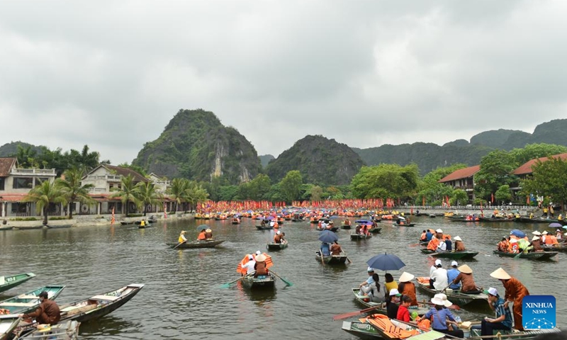 Tourists take boats to travel across the Tam Coc-Bich Dong scenic area in northern Vietnam's Ninh Binh province, May 21, 2022.Photo:Xinhua