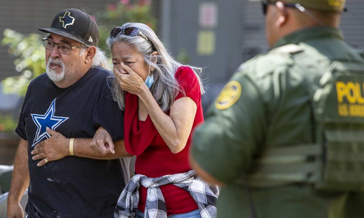 A woman cries Tuesdayas she leaves the Uvalde Civic Center. At least 14 students and 1 teacher were killed after a gunman opened fire at Robb Elementary School in Uvalde on May 24. Photo: IC