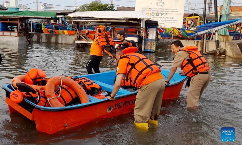 Photo taken with a mobile phone on May 23, 2022 shows search and rescue team members preparing a boat to evacuate people in flood water triggered by high tides and broken embankment at Tanjung Emas Port on the coast of Semarang, Central Java, Indonesia.(Photo: Xinhua)